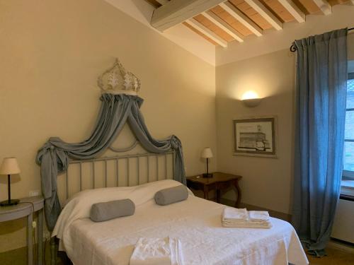 a bedroom with a white bed with a canopy at Borgo Montefreddo Toscana in San Casciano dei Bagni
