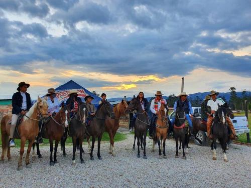 un groupe de personnes à cheval sur une route dans l'établissement Mirador Casa Blanca Campestre, à Tibasosa