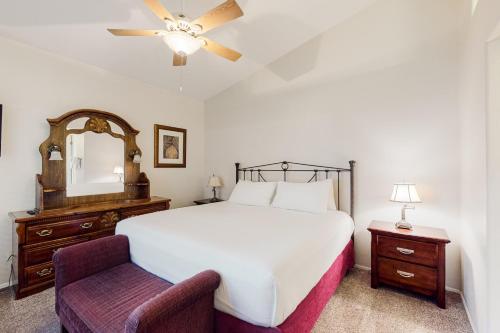 a bedroom with a bed and a chair and a mirror at Tucson National #8689 in Tucson