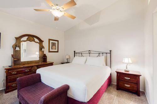 une chambre avec un lit, une chaise et un miroir dans l'établissement Tucson National #8689, à Tucson