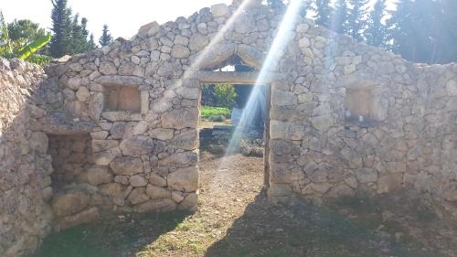 ein altes Steingebäude mit einer Steinmauer in der Unterkunft Masseria Petra in Martano