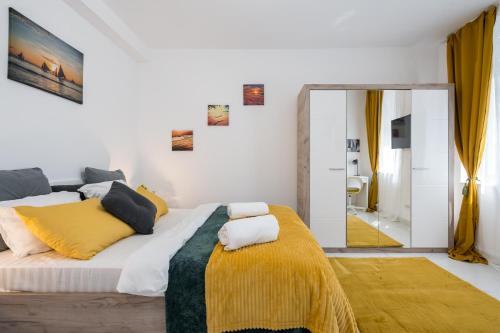 sypialnia z dużym łóżkiem i żółtym kocem w obiekcie Light-Monza-Unirii w Bukareszcie