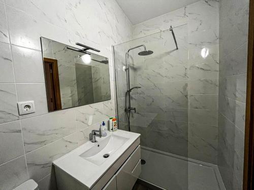 ein Bad mit einem Waschbecken, einer Dusche und einem Spiegel in der Unterkunft Casa do Pastor in Carragozela