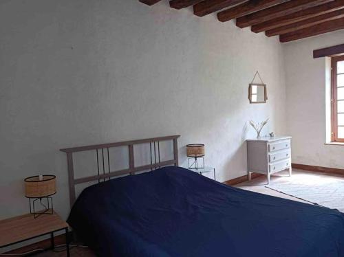 - une chambre avec un lit bleu et un mur blanc dans l'établissement Maison de famille - grand jardin clos - 15mn du zoo de Beauval, à Selles-sur-Cher