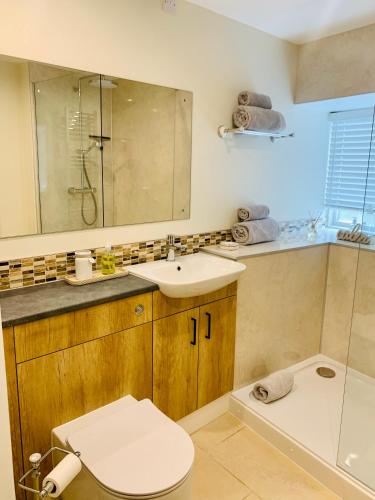a bathroom with a sink and a toilet and a tub at The Beautiful Bobbin - Premium Cottage with views, local walks, wood burner & pubs in Tideswell