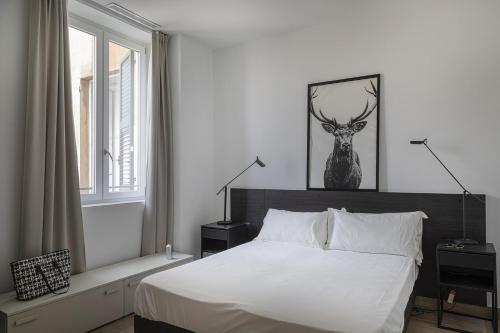 um quarto com uma cama e uma imagem de veado na parede em Attico 28 by Wonderful Italy em Gênova
