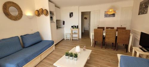 un salon avec un canapé bleu et une table dans l'établissement Bright cocoon with garden and sea view, à Grimaud