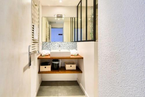 une salle de bain avec un lavabo et un miroir dans l'établissement Residence Les Balcons de Collioure - maeva Home, à Collioure