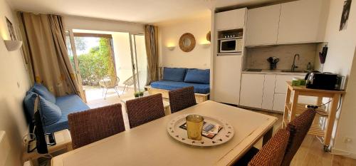 une cuisine et une salle à manger avec une table et des chaises dans l'établissement Bright cocoon with garden and sea view, à Grimaud