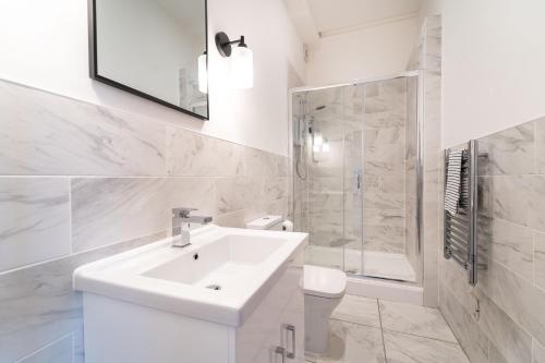 Baño blanco con lavabo y aseo en 2 The Quadrant Luxury Apartments - Hoylake en Hoylake