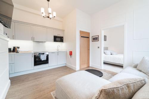 2 The Quadrant Luxury Apartments - Hoylake في هويليك: غرفة معيشة مع أريكة ومطبخ