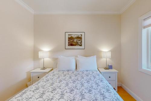 a white bedroom with a bed with two lamps at Granite Tranquility in Yosemite West