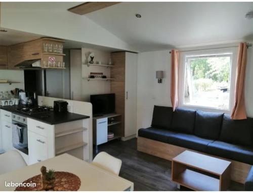 une cuisine et un salon avec un canapé et une table dans l'établissement sweet mobil-home, à Lège-Cap-Ferret