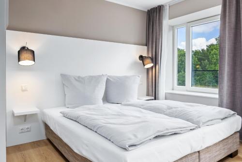 Un dormitorio blanco con una cama grande y una ventana en Strandresidenzen Binz-Prora Strandresidenzen Binz-Prora V0 3, en Binz