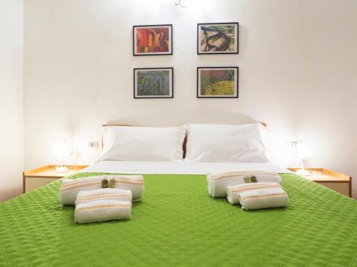 1 dormitorio con 1 cama verde y 3 toallas en Casa Mazzini en Iglesias