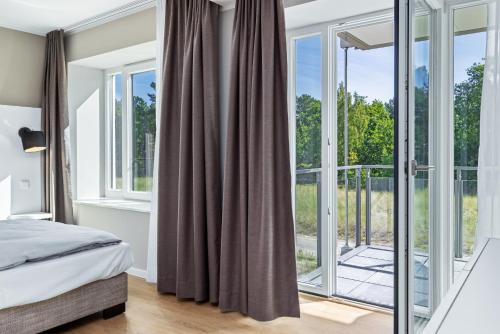 ein Schlafzimmer mit einem Bett und einem Balkon in der Unterkunft Strandresidenzen Binz-Prora Strandresidenzen Binz-Prora V0 1 in Binz