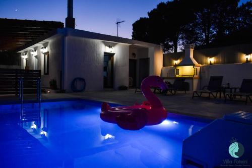 czerwony łabędź w basenie w nocy w obiekcie Villa Foteini w mieście Yerakárion
