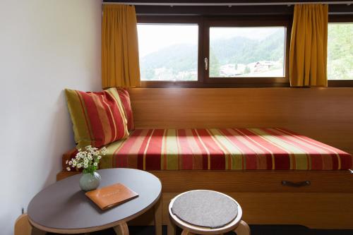 a room with a bench with a table and a window at Familienhotel Mateera Gargellen / Montafon in Gargellen