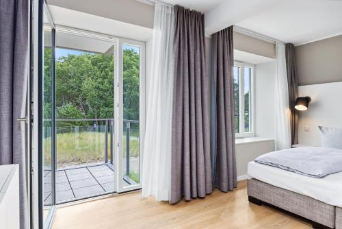 a bedroom with a bed and a large window at Strandresidenzen Binz-Prora Strandresidenzen Binz-Prora V0 2 in Binz