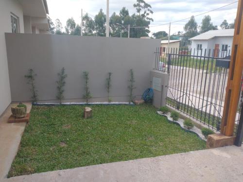 a backyard with a fence and a yard with plants at Residencial Adventus II in Venâncio Aires