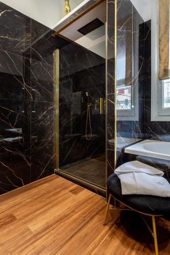 a bathroom with a shower and a tub and a chair at Maison d'Or in Genova