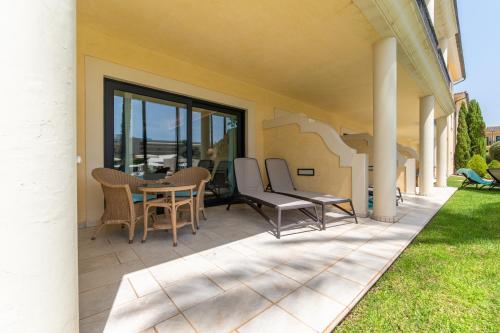 a patio with chairs and a table on a house at CM Mallorca Palace - Only Adults in Sa Coma