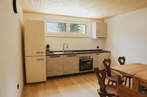 a kitchen with a table and a sink and a refrigerator at Wild Side in Mollia