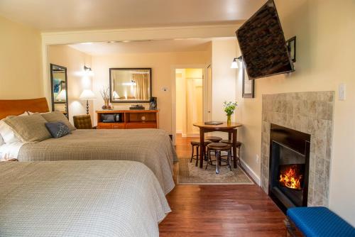 a bedroom with two beds and a fireplace at Inn at Buckhorn Cove in Little River