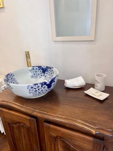 un bol bleu et blanc sur une armoire en bois dans l'établissement Maison de Mags & Mags Willow Room, à Lanouaille