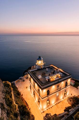 a lighthouse on top of a building in the water at Faro Punta Imperatore in Ischia