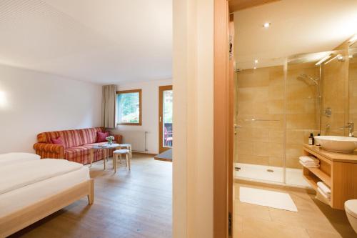 ein Bad mit einem Waschbecken und einer Dusche in einem Zimmer in der Unterkunft Familienhotel Mateera Gargellen / Montafon in Gargellen