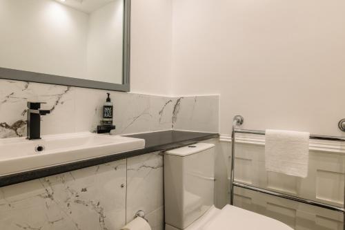 a white bathroom with a sink and a toilet at Muthu Belstead Brook Hotel in Ipswich