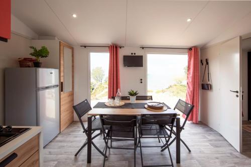 a kitchen with a table and chairs in a kitchen at Camping de Brouël in Ambon