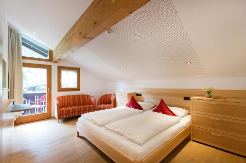 a bedroom with a bed with red pillows on it at Familienhotel Mateera Gargellen / Montafon in Gargellen