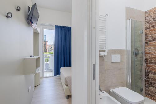 a bathroom with a shower and a toilet and a sink at Hotel Madera in Lido di Jesolo