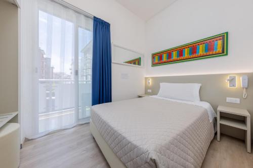 a bedroom with a bed and a large window at Hotel Madera in Lido di Jesolo