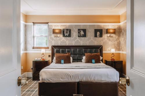 a bedroom with a large bed and two night stands at Muthu Belstead Brook Hotel in Ipswich
