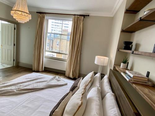 a living room with a large bed and a window at Top floor luxury 3 bedroom near Baker St in London