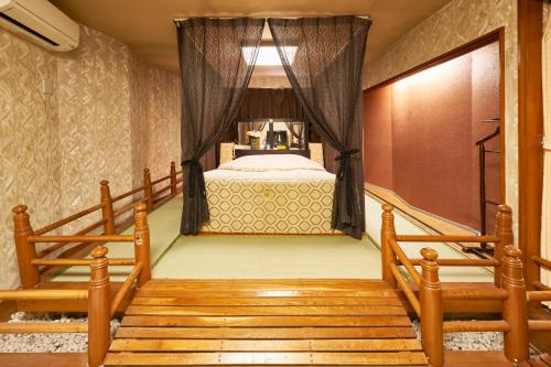 a bedroom with a bed and a stairway leading to a room at ホテル　モモ 