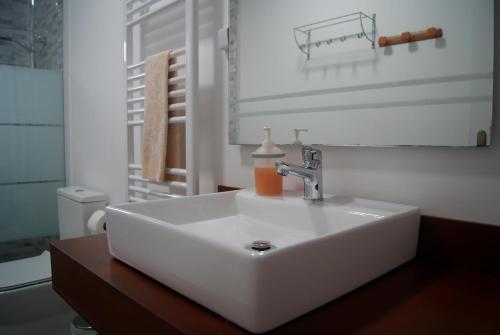 a white sink with a soap bottle on top of it at Aguieira STAY in Castro Daire