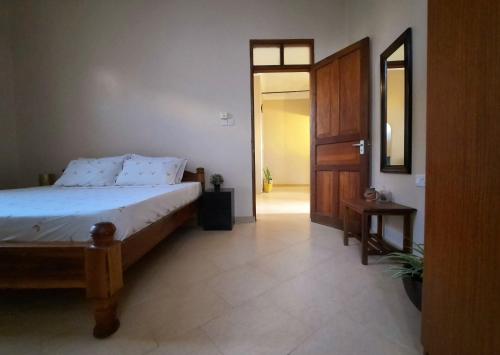 ein Schlafzimmer mit einem Bett und einer Tür zu einem Flur in der Unterkunft Modern apartment in Stone Town in Stone Town