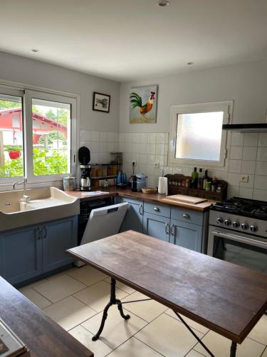 une cuisine avec des placards bleus et une table en bois dans l'établissement Villa proche Arcachon, Dune, Plages, à La Teste-de-Buch