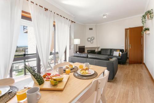 eine Küche und ein Wohnzimmer mit einem Tisch und Obst darauf in der Unterkunft Seaside Deluxe Flat in Peniche