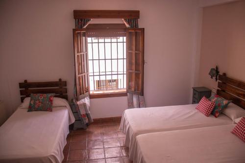 a room with two beds and a window at Hotel Casa de las Piedras in Grazalema