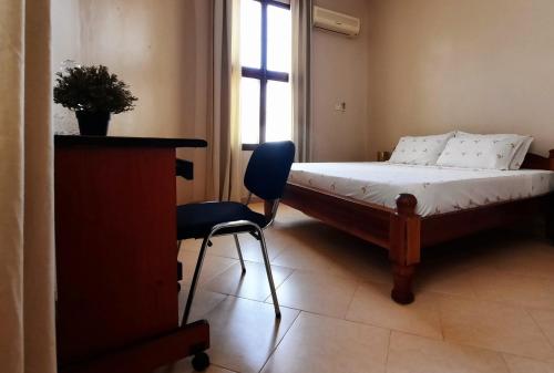 a bedroom with a bed and a chair and a window at Modern apartment in Stone Town in Stone Town