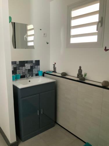 un bagno con lavandino e specchio di Gwada Siéva a Baie-Mahault