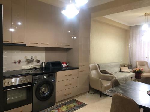 een keuken met een wasmachine, een bank en een tafel bij the best apartment in Koetaisi