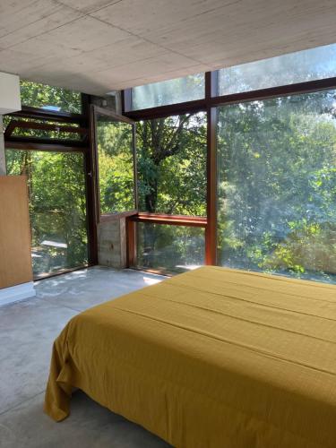 ein Schlafzimmer mit großem Bett und großen Fenstern in der Unterkunft CASA RIO VEZ - Riverfront in Arcos de Valdevez