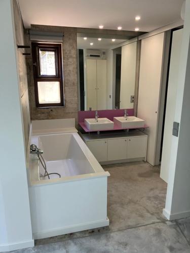 a bathroom with two sinks and a large tub at CASA RIO VEZ - Riverfront in Arcos de Valdevez