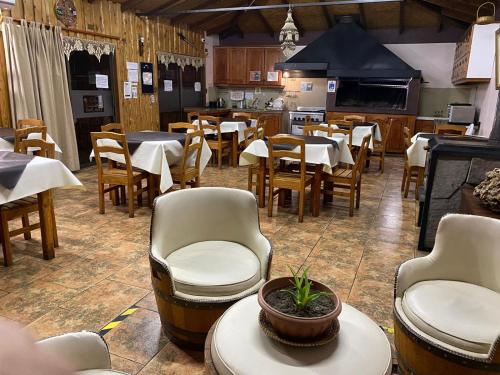 比亞里卡的住宿－Hostal Y Cabañas Don Juan，用餐室配有桌椅和桌子。